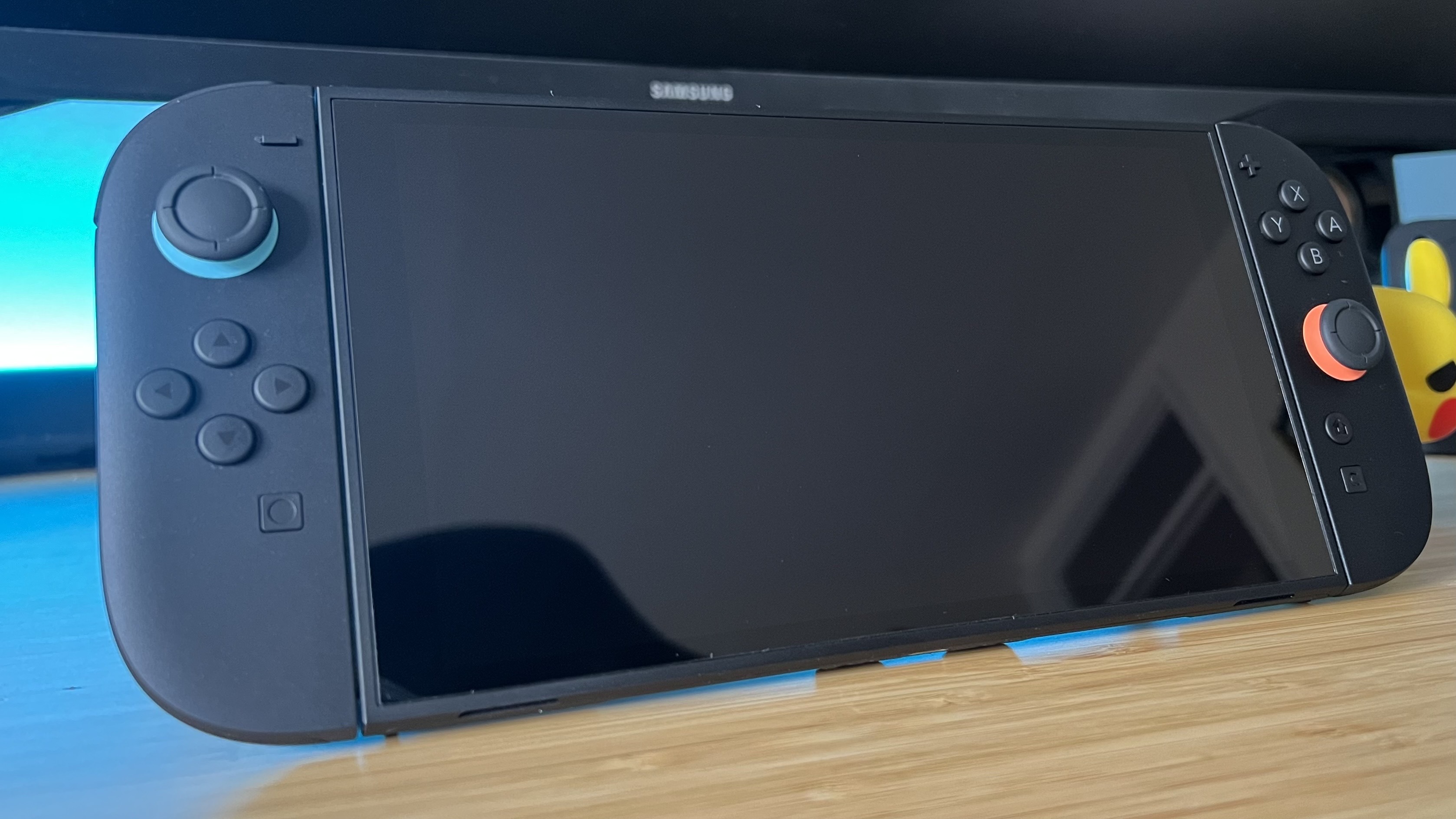 Nintendo Switch with screen off sitting on a wooden desk