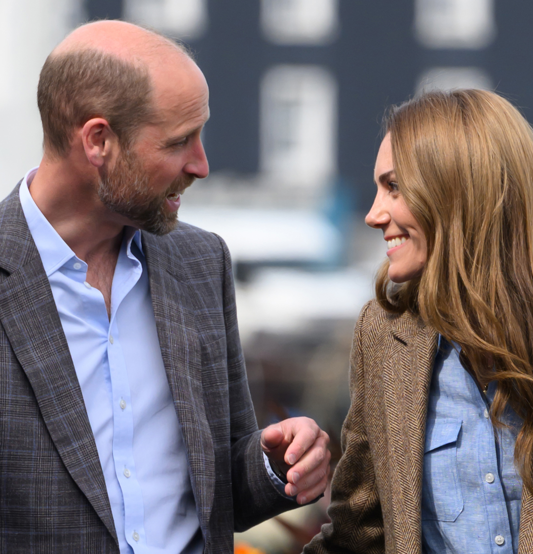 Prince William and Kate Middleton smiling wearing blazers