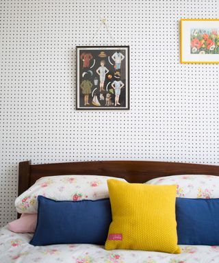 bedroom with dotted wallpaper wooden bed with floral bed sheet and frame on wall