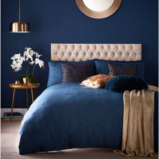 bedroom interior with bule wall and bedding with blue colour cushions