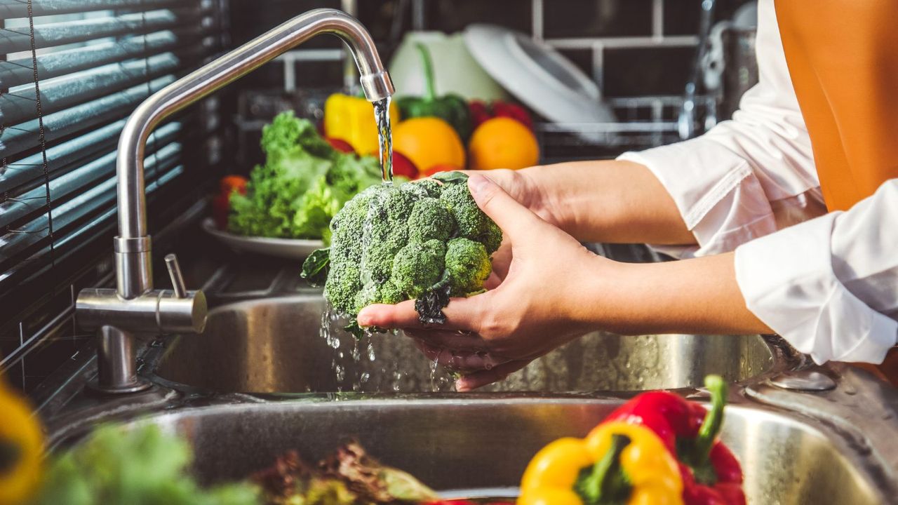 Someone washing fresh produce in a sink