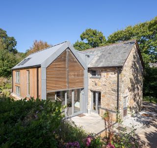 double storey extension to stone barn with timber and zinc cladding