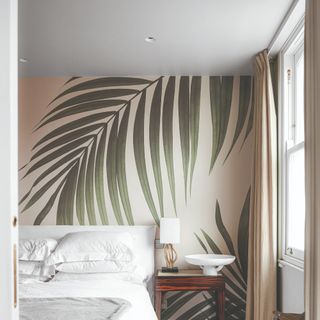A bedroom with a tropical wallpaper