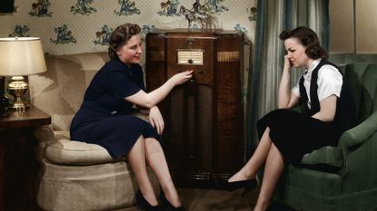 Two women listen to a radio in the 1930s (black and white)