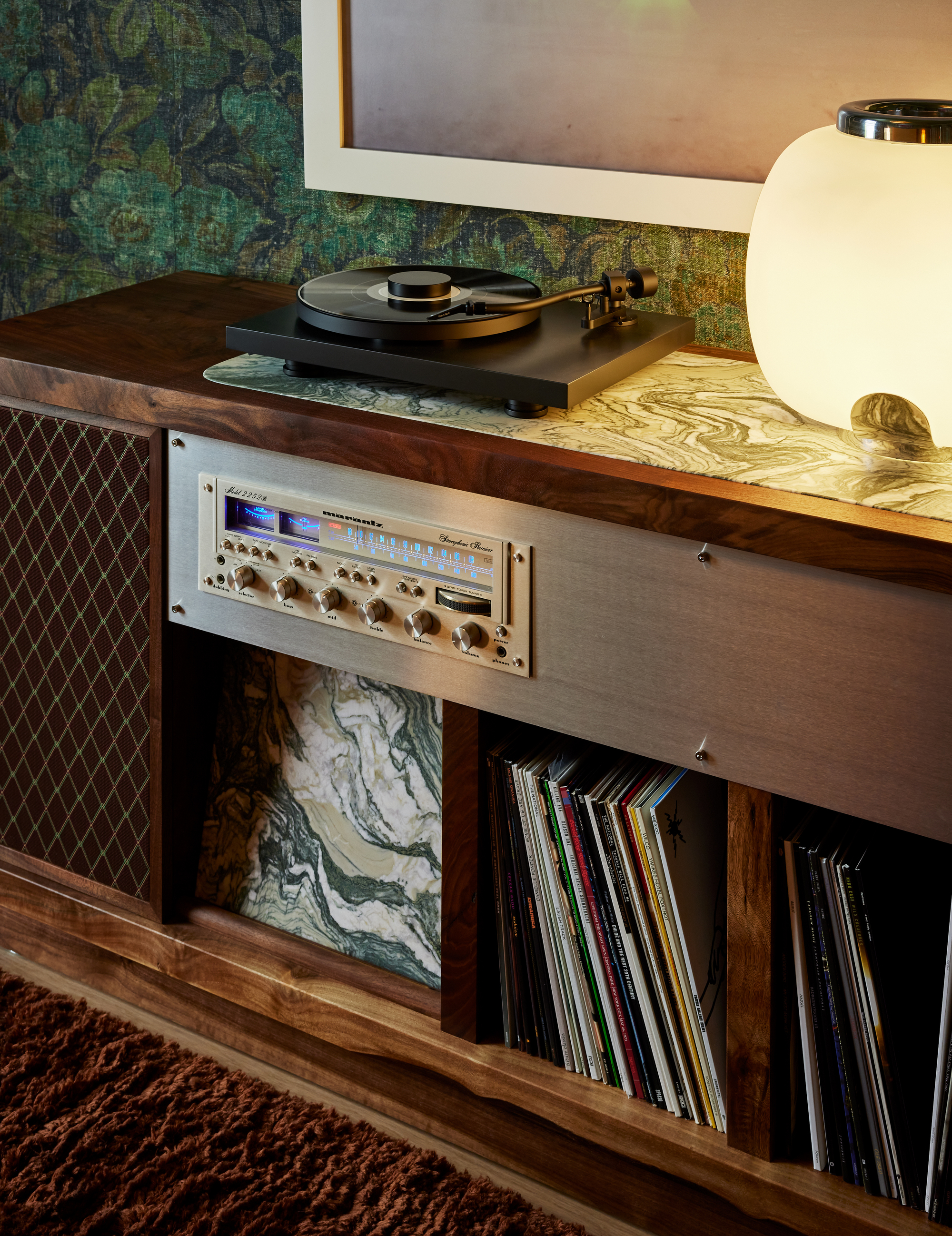 Close-up image of a long and low wooden record storage cabinet and built-in speaker.
