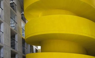 A striking yellow reinforced concrete staircase leads from the multi-functional ground level, up to the associations' offices