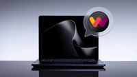 A sleek Surface Laptop UItra with a glossy abstract wave on screen sits against a pale gray backdrop, beside a speech-bubble icon with a colorful W logo.