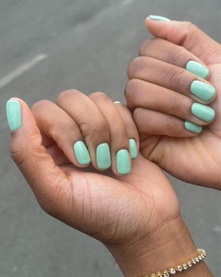 The woman's hands are painted with turquoise nails.