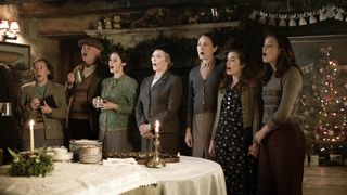 Mrs Pumphrey (Patricia Hodge), Mrs Hall (Anna Madeley), Helen (Rachel Shenton) and Jenny (Imogen Clawson) in wartime clothes sing in the pub in All Creatures Great and Small.