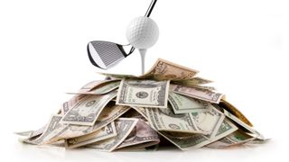 Golf ball lying on a stack of dollar bills