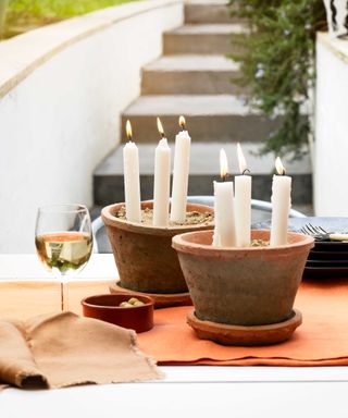 candles in pots on outdoor dining table