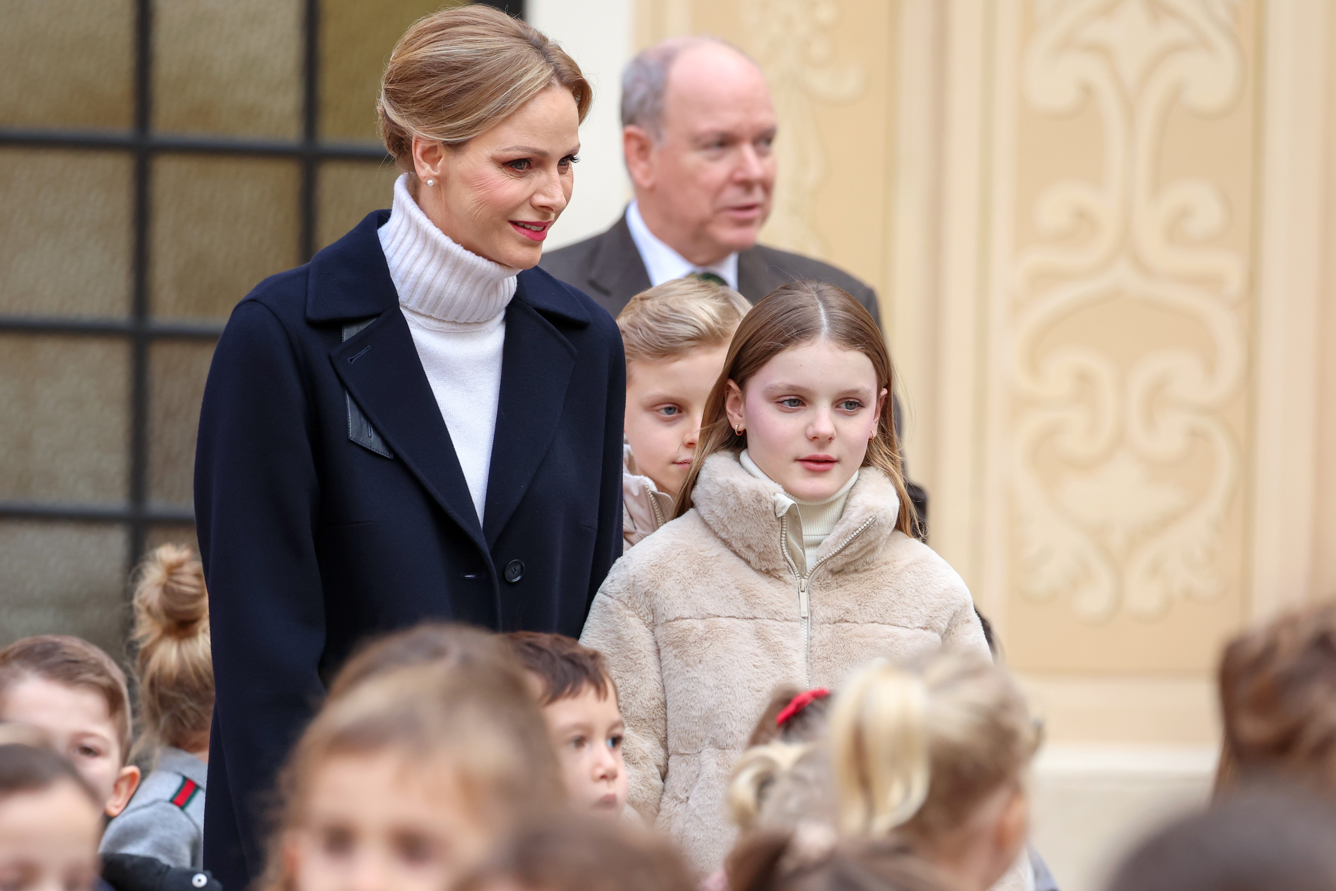 Princess Charlene and Prince Albert standing with Princess Gabriella outside the palace