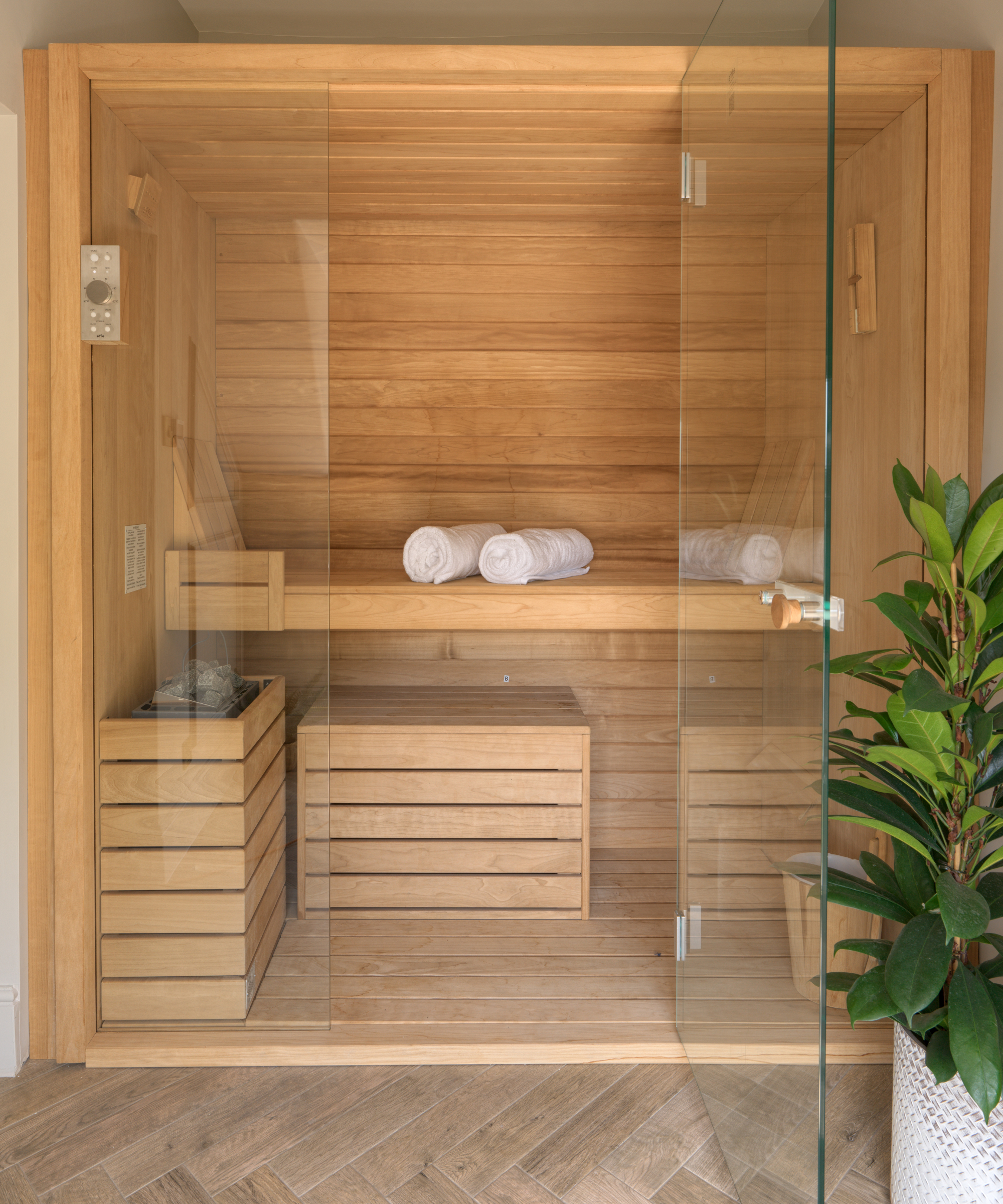 wooden sauna in bathroom with glass doors