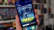 Netflix running on iPhone 17 Pro Max (being held with room in background)