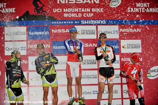 The men's podium gets wet with champagne.
