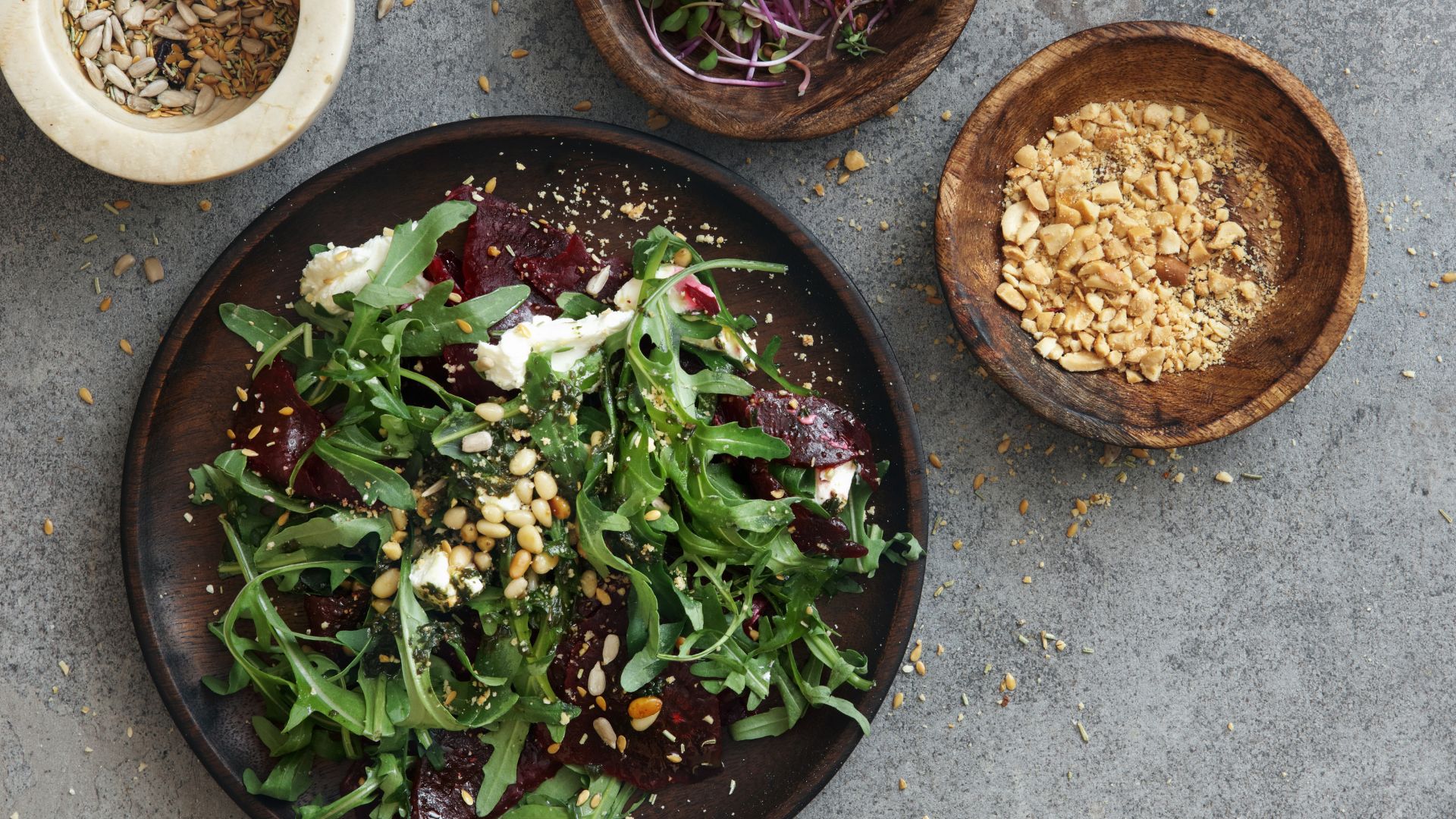 Bowl of salad with crunchy toppings with peanuts and seeds