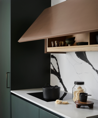 black and white marble splashback in kitchen with copper cabinet top