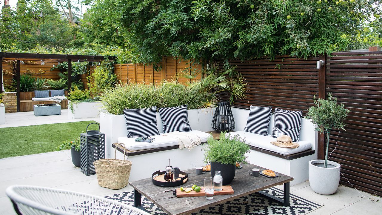 view of the garden with the two seating areas and lawn in between. A garden makeover to create a seating area, in a small garden 