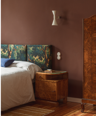 A brown bedroom with vintage elements, burl furniture and fabric pattern panel headboard by Studio Bosko