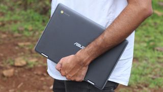 A young professional carrying an Asus Chromebook