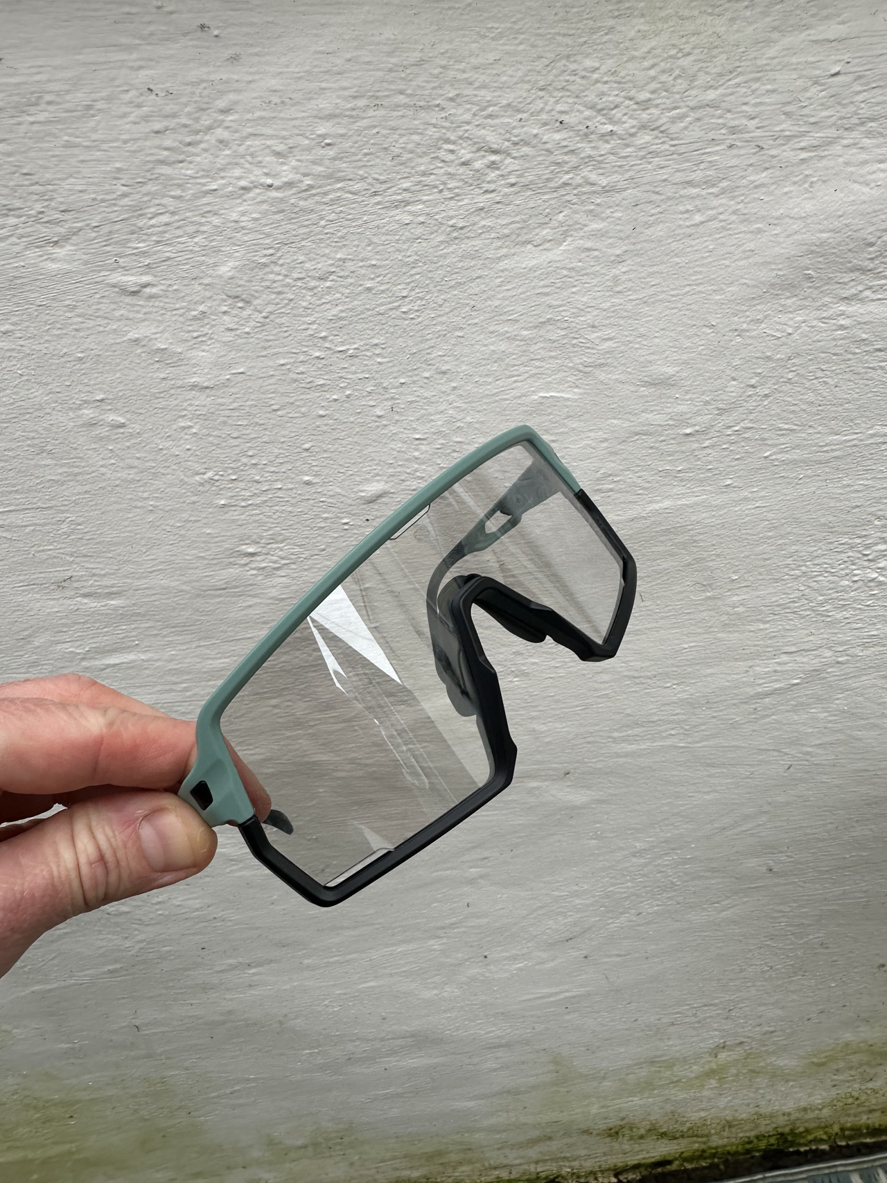 Sunglasses against a white wall