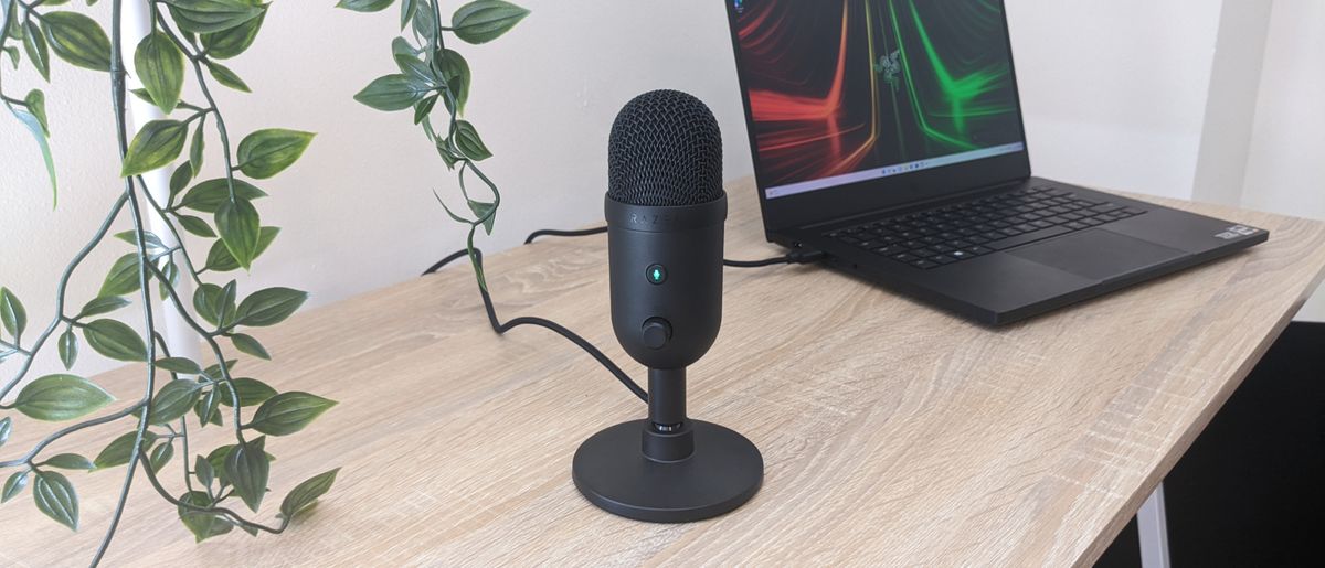 Razer Seiren V2 X USB microphone on a wooden desk, plugged into a Razer Blade 14 laptop.