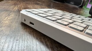 The Logitech MX Keys Mini for Mac keyboard on a wooden desk