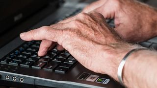 Fingers typing on a computer keyboard.