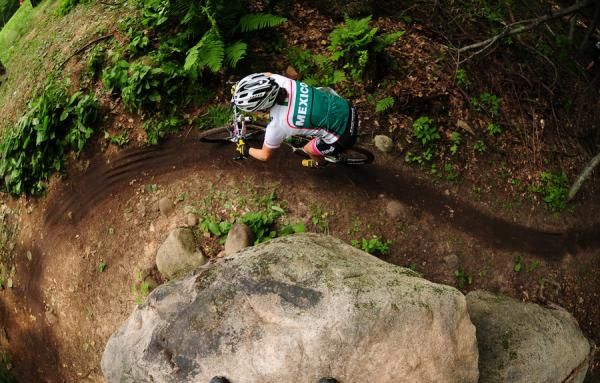 A rider from Team Mexico rounds a large boulder