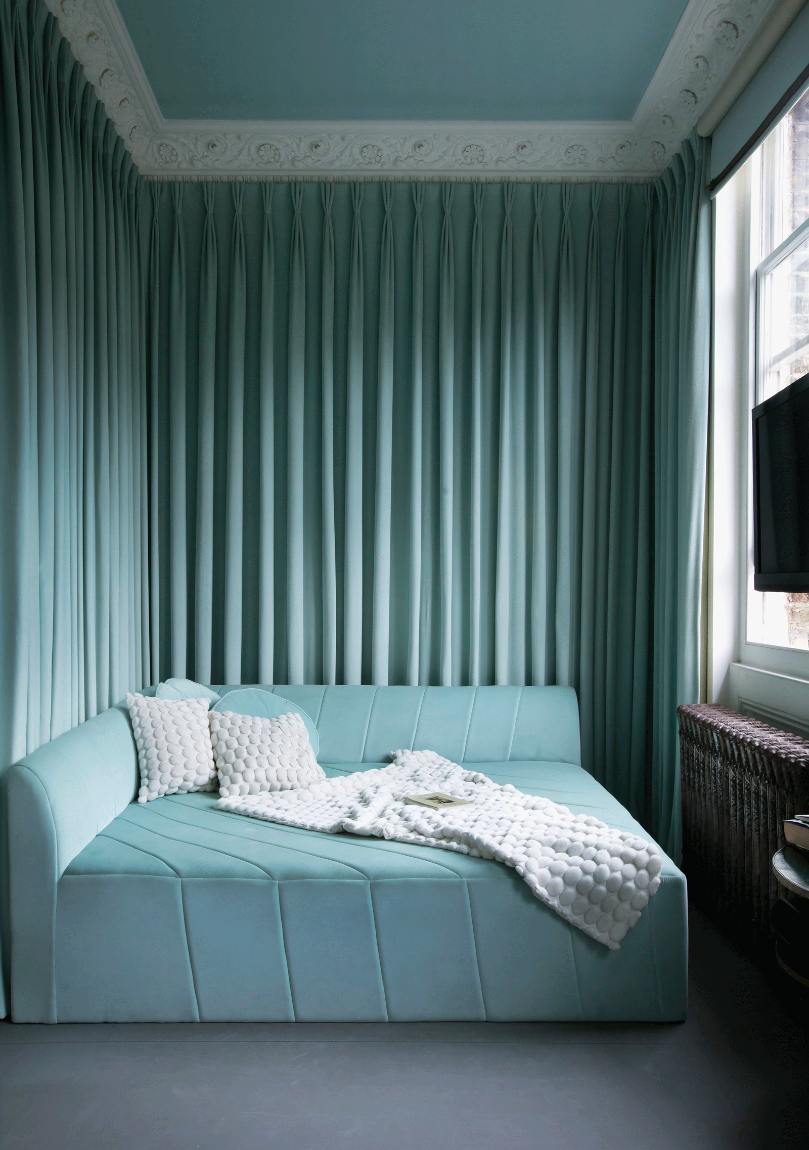 Blue bedroom with curtains hanging from the walls