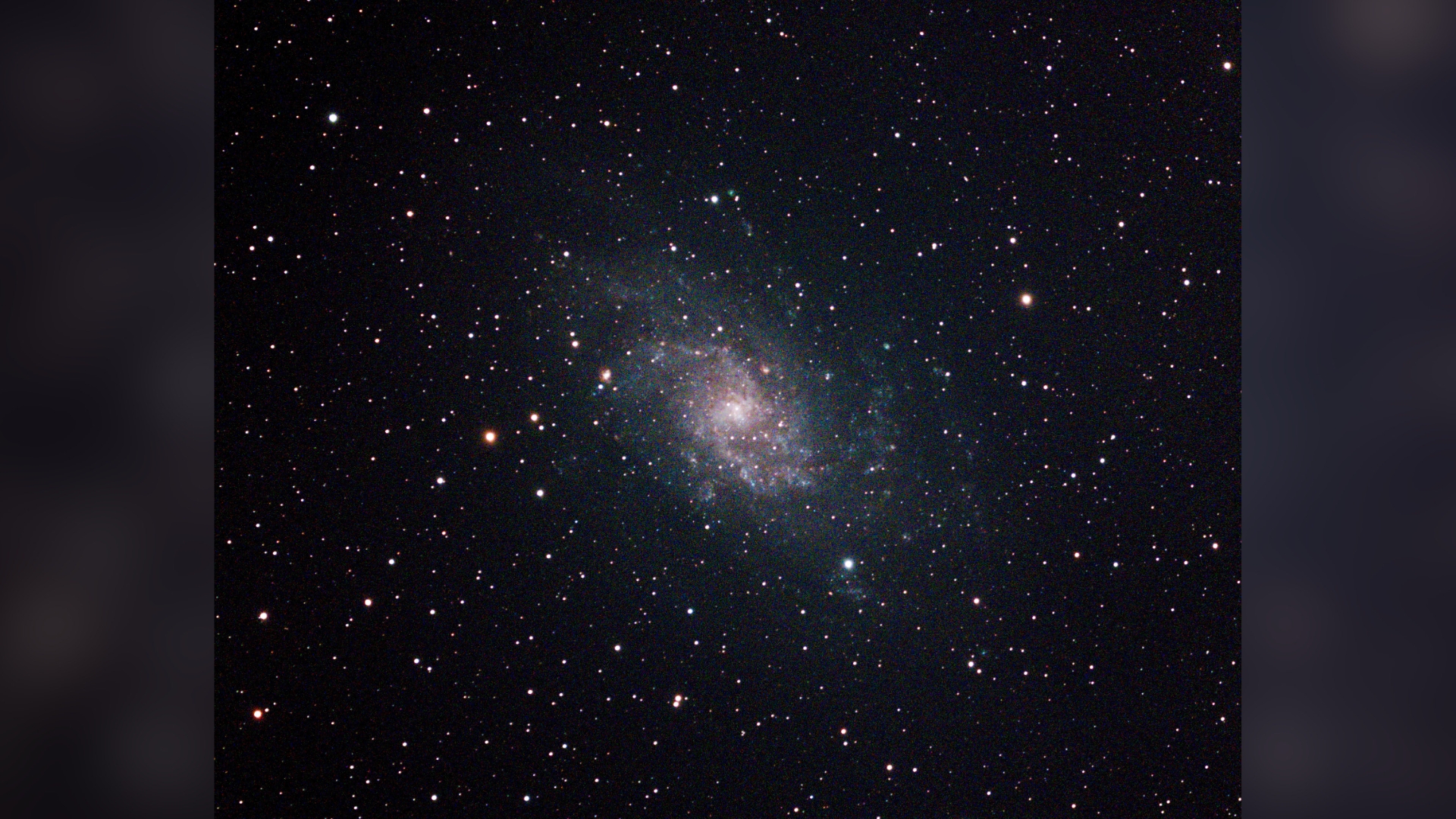 a glittering spiral galaxy glowing hues of blue and pink against a background of stars