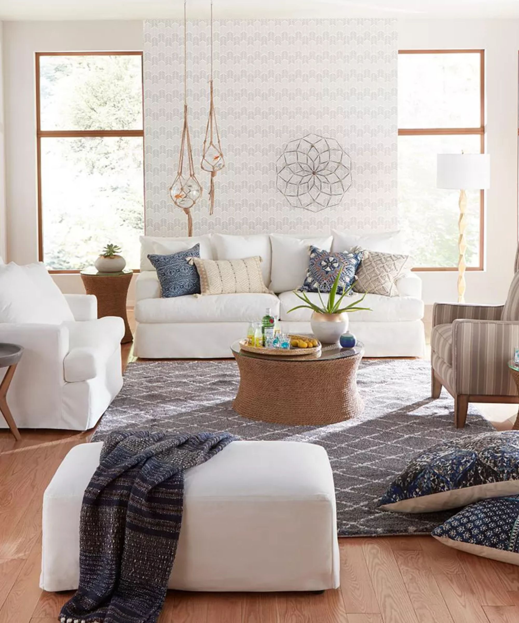 neutral living room with white couch, matching armchair and ottoman with coastal style