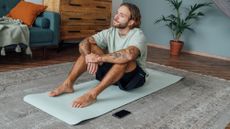 A man sitting on a yoga mat