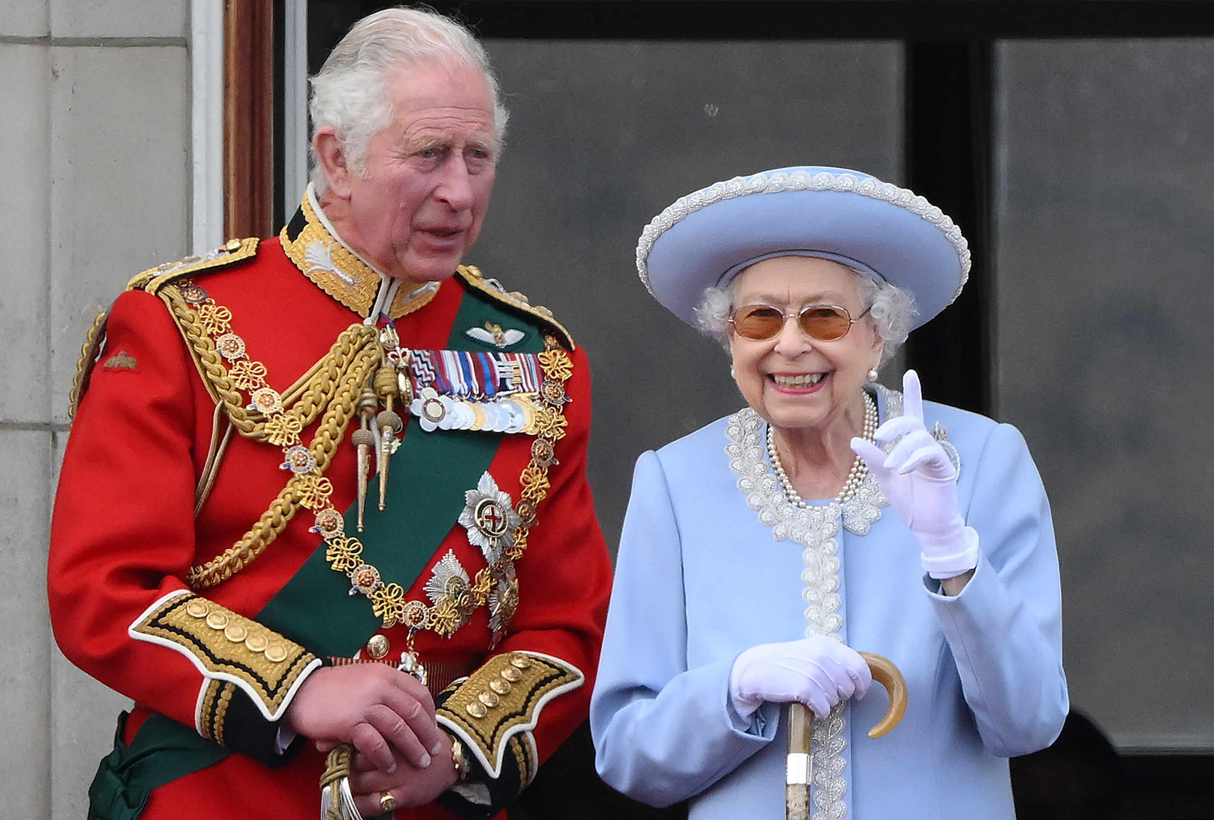 Queen Elizabeth smiling and pointing next to King Charles at Trooping the Colour