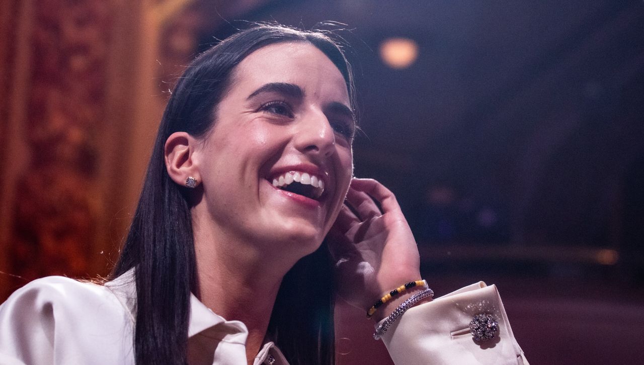 Caitlin Clark at the WNBA draft wearing a white Prada jacket