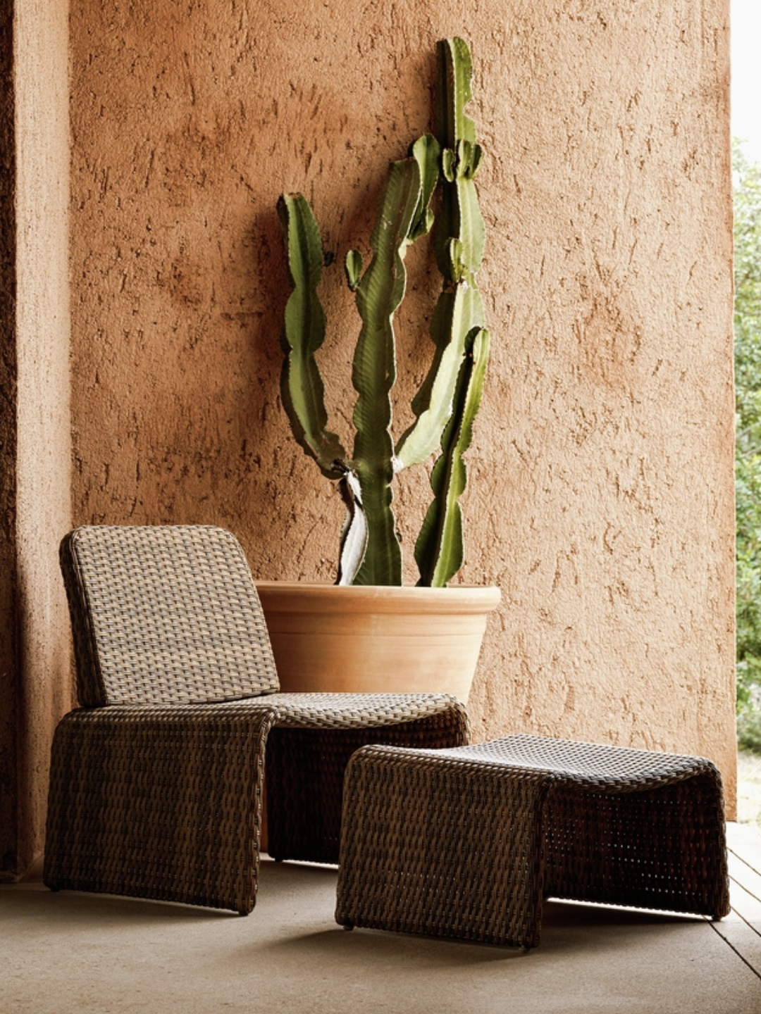 A brown outdoor rattan chair and footrest from Habitat
