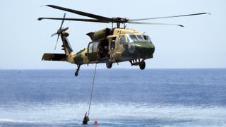 A helicopter hovering over water in Special Forces: World's Toughtest Test