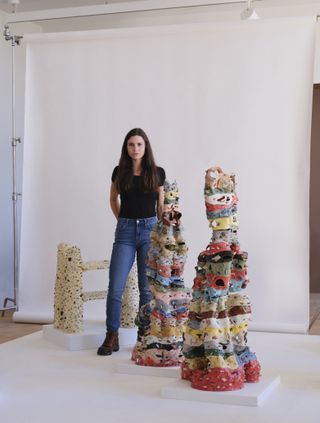Artist standing beside her art work in an exhibition
