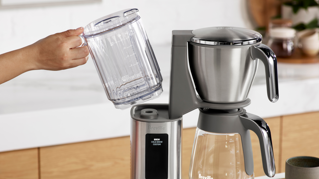 Person removing water tank from Breville Luxe Brewer coffee maker