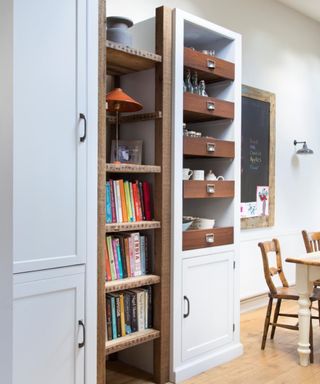 Grey kitchen storage, fitted drawers, wood flooring, cookbooks