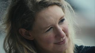 An extreme close up of Elizabeth Holmes looking to her left with messy hair in You Can See Everything