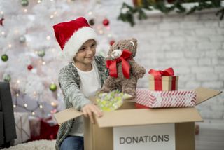 child carrying box of Christmas gift donations