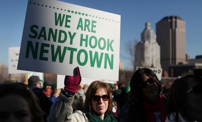 A woman holds up a sign during a Feb. 14 rally at the Connecticut State Capital to promote gun-control legislation.