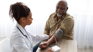 female doctor taking a man's blood pressure