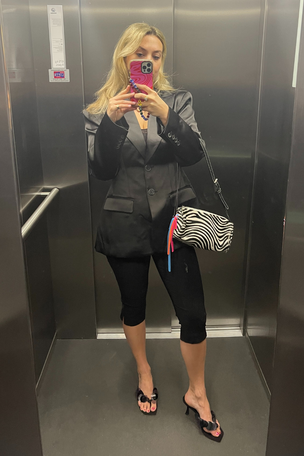 Clementina Jackson wears black capri pants, black blazer and zebra print bag