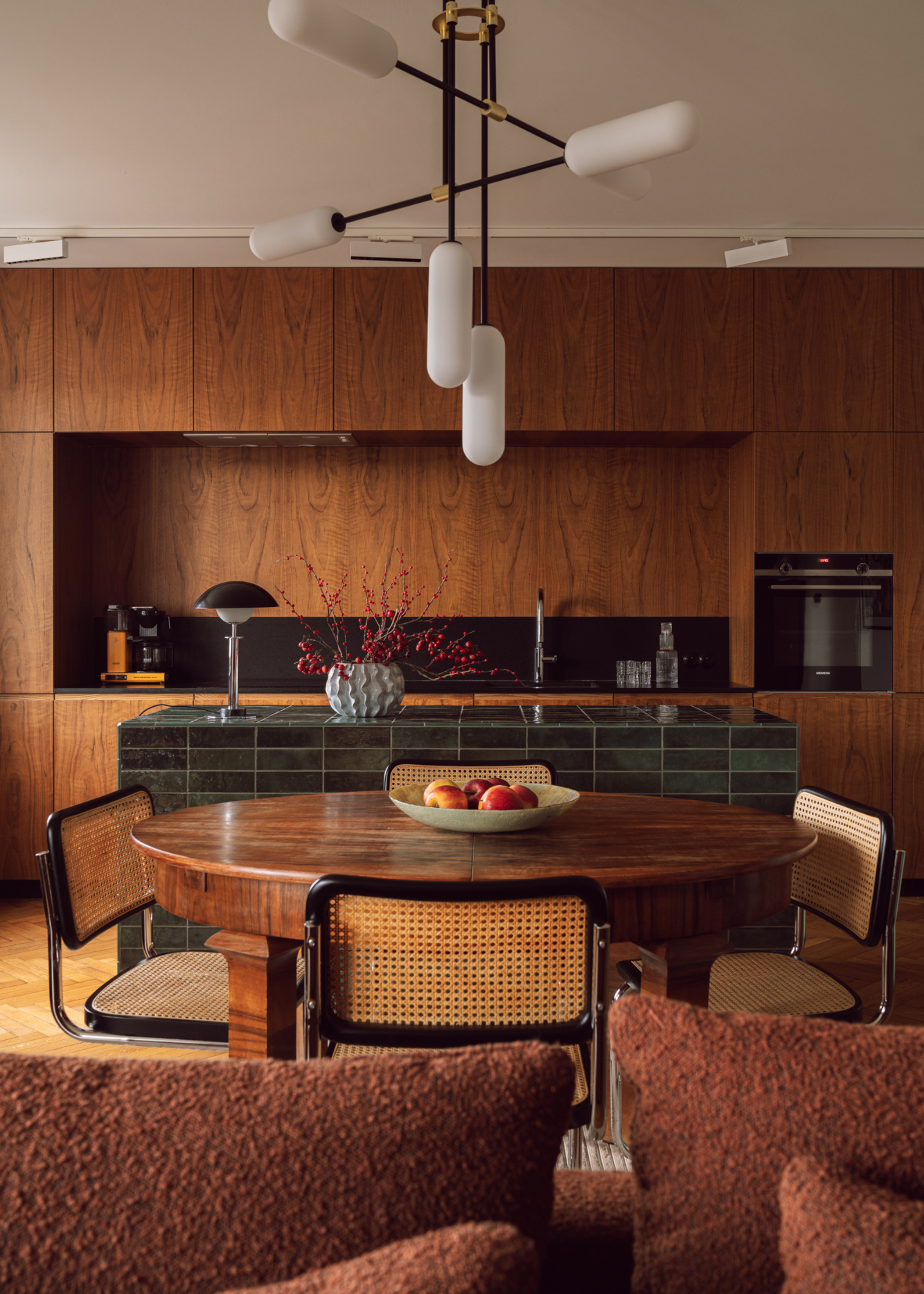a sleek wooden clad kitchen design with a green tiled kitchen island