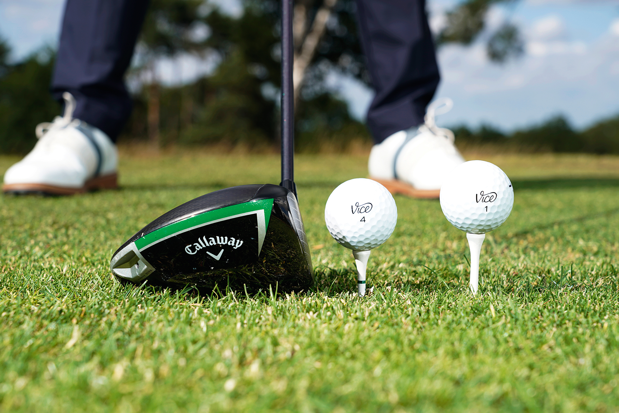 Alex Elliott demonstrating the correct ball position to hit longer drives, with the ball closest to the driver being a fairway finder height and the one further from the driver being the longer hitting height