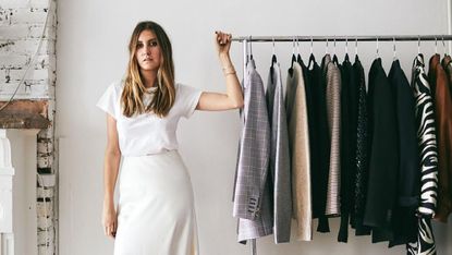 Allison Bornstein stands next to a rail of clothes.