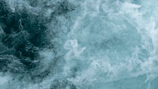 A swirl of blue and white shows ocean waves roiling in the water