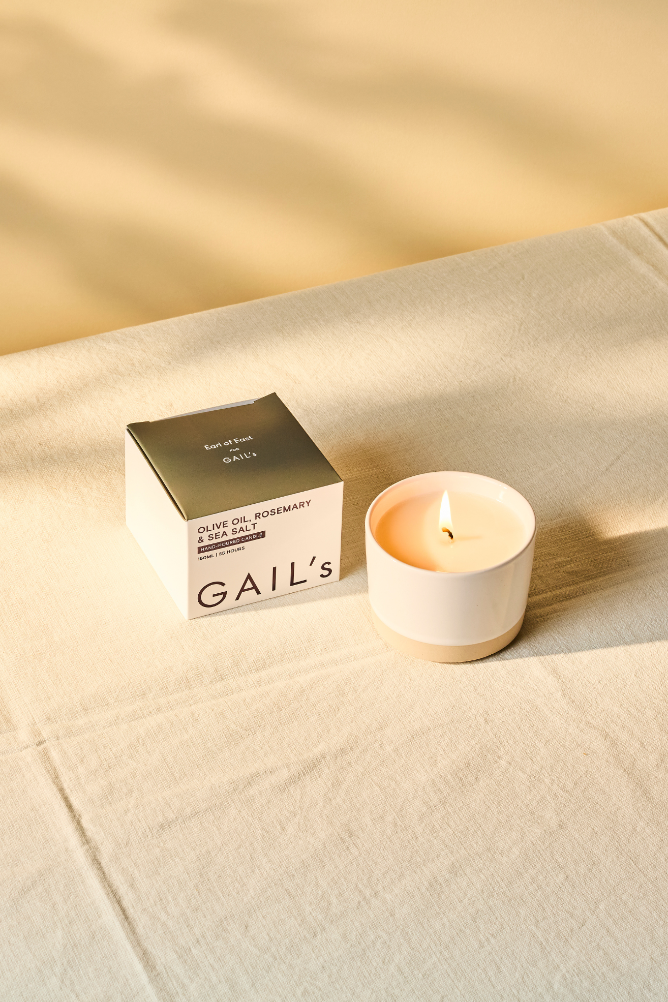 A white ceramic candle on a linen tablecloth